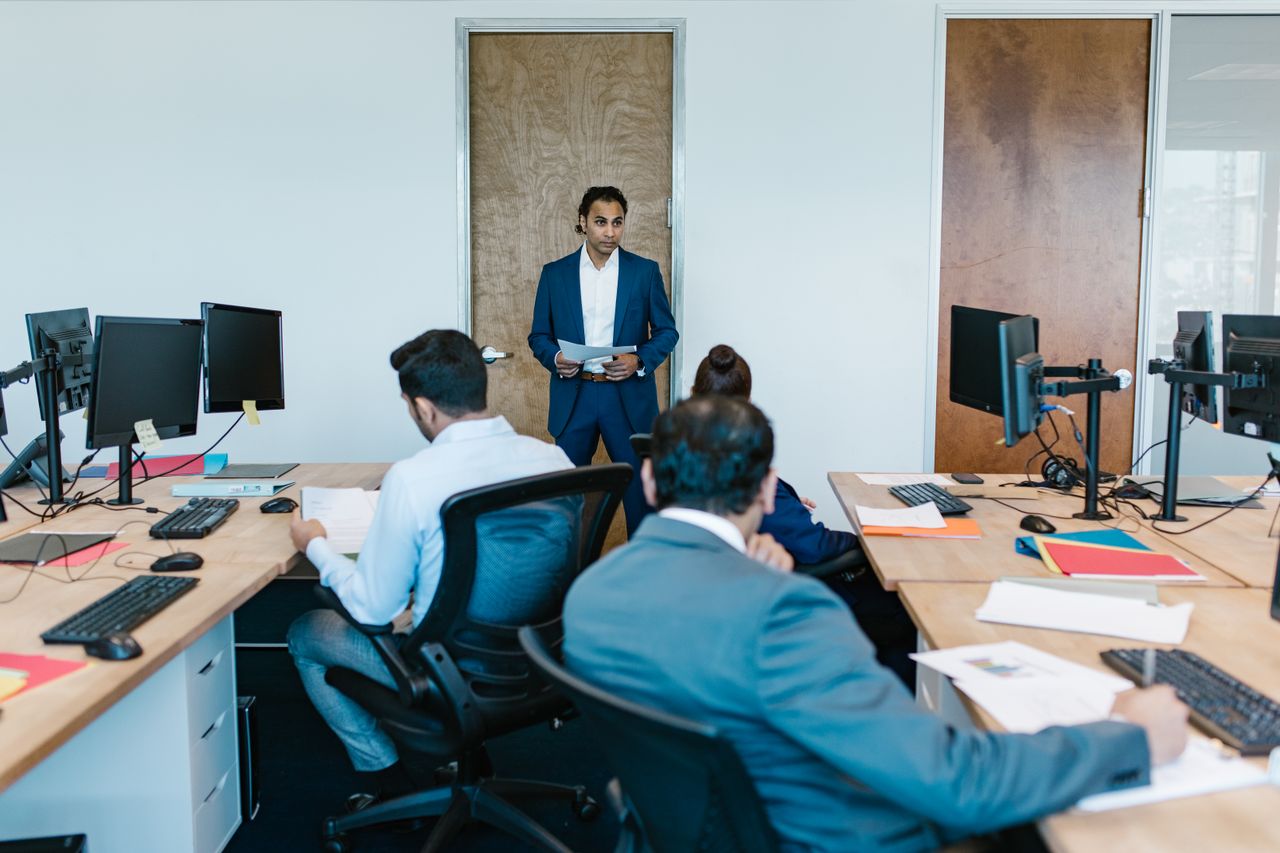 Services Business meeting with diverse team in modern office space, discussing projects.